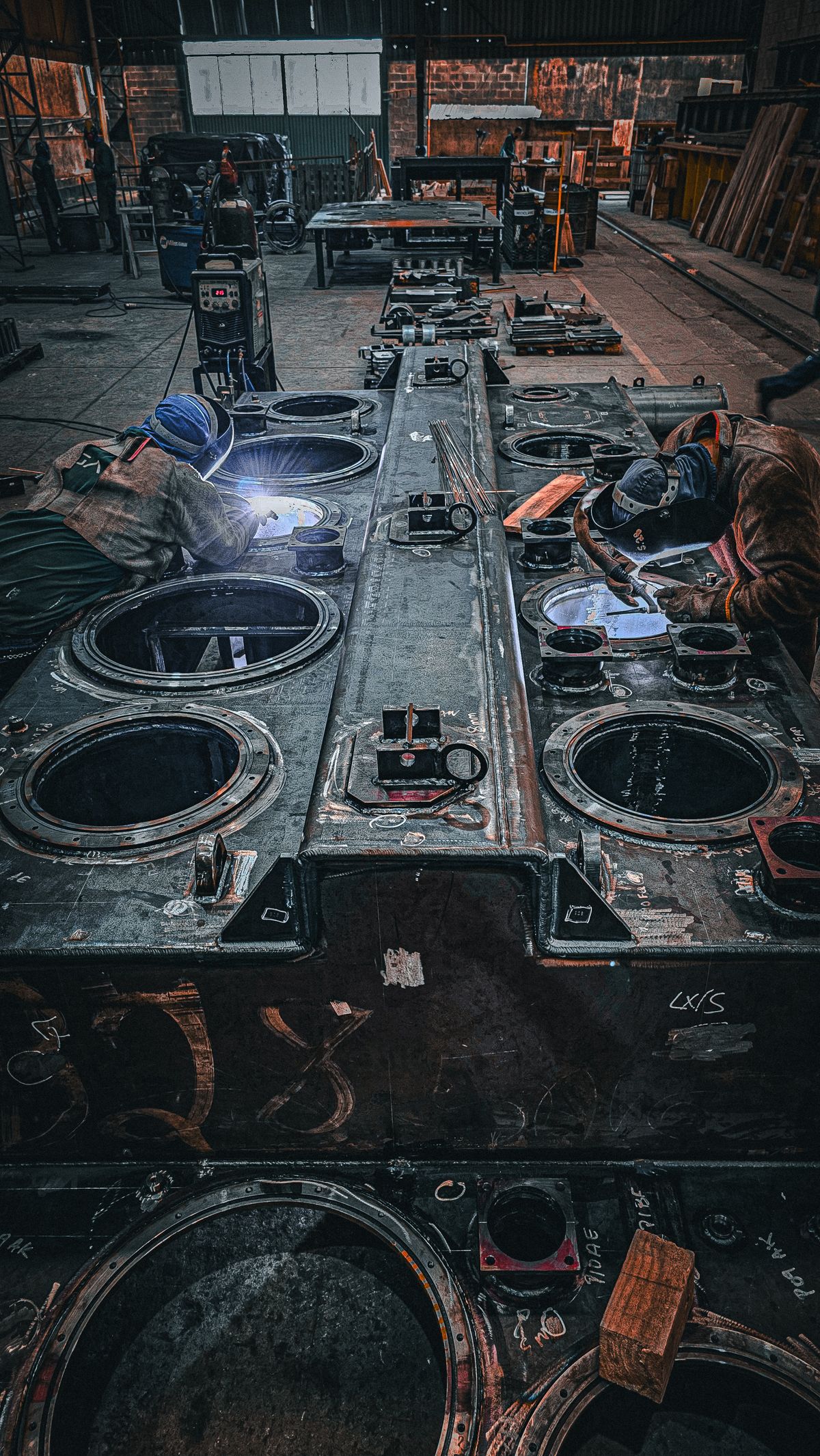 Skilled workers welding large metal components in a manufacturing facility